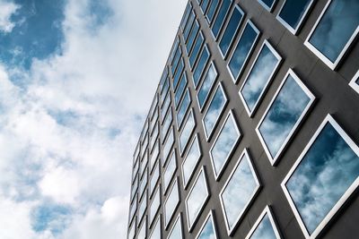 Low angle view of modern building against cloudy sky