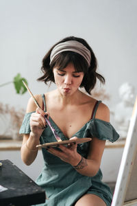 Female painter mixing paint on palette at art studio