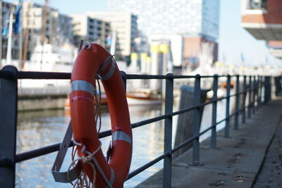 Life belt on railing by river in city