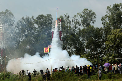 Crowd looking at rocket launch 