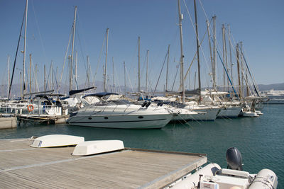 Sailboats moored on sea against sky