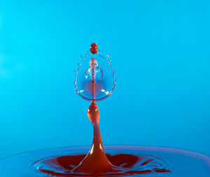 Close up of liquid splashing against blue background