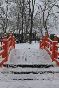 Snow covered field by trees