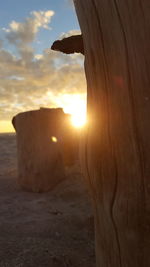 Close-up of wooden post against sky during sunset