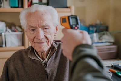 Portrait of man using mobile phone at home