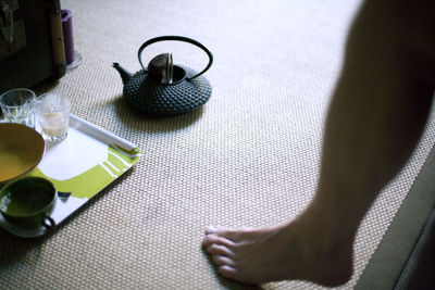 Early morning, young man getting up and drinking tea, leg and barefoot , home 