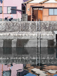 Reflection of houses on lake in city