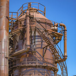 Low angle view of crane against clear blue sky