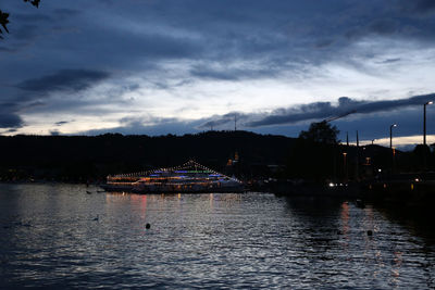 Scenic view of lake by buildings against sky at dusk