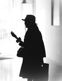 Silhouette woman standing against wall