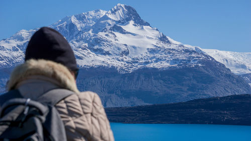 Rear view of person on snowcapped mountains against sky