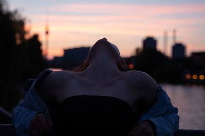 Woman standing against sky during sunset