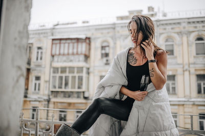 Full length of woman standing against building in city