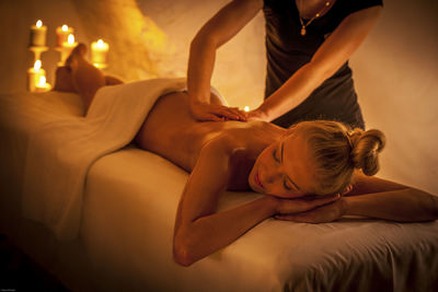 Relaxed young woman receiving massage in spa