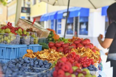 Young woman buying fruit at local farmers market. fresh organic produce for sale at  farmers market.