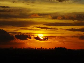 Silhouette landscape against dramatic sky during sunset