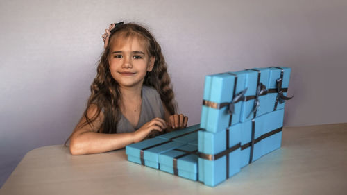 Portrait of smiling young woman sitting on table