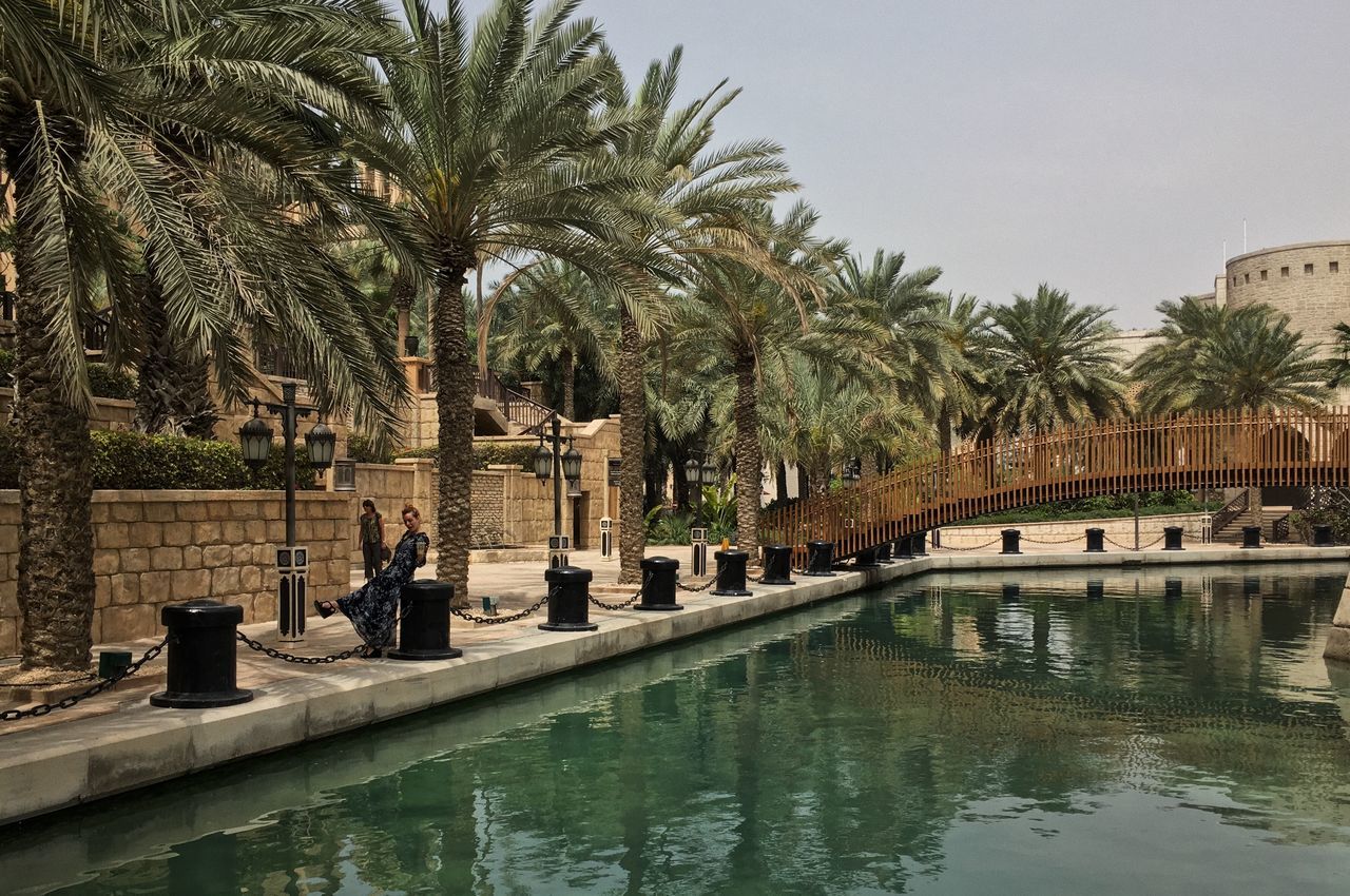 PEOPLE RELAXING BY SWIMMING POOL IN PARK