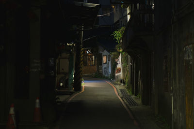 Narrow street amidst buildings in city at night