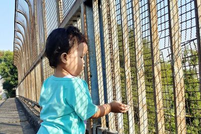 Side view of little baby girl playing by the roadside