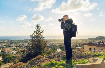 Man photographing cityscape against sky