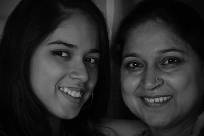 Close-up portrait of smiling mother and daughter 