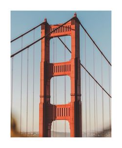 Low angle view of suspension bridge against sky