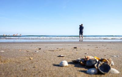 Full length of man on beach against clear sky