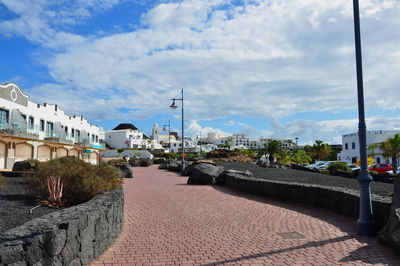 Street amidst buildings against sky in city