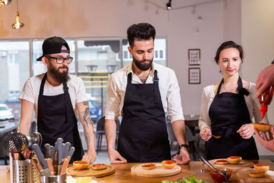 Portrait of male friends having food at home