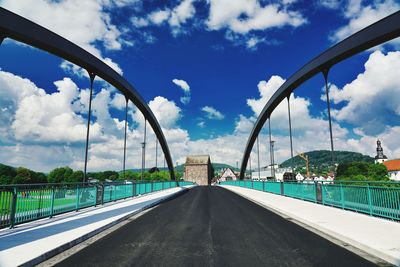Road by bridge against sky in city