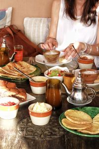 Midsection of woman having food on table