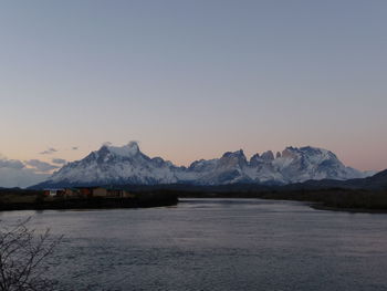 Scenic view of lake and snowcapped mountains against clear sky