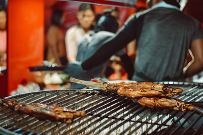 Midsection of man preparing food on barbecue grill