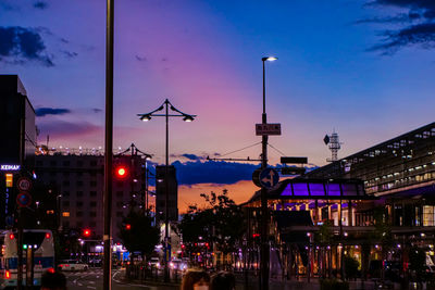 City street and buildings against sky at dusk