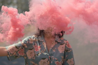 Close-up of man amidst pink smoke