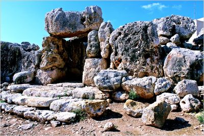 Stone wall on rocks against sky