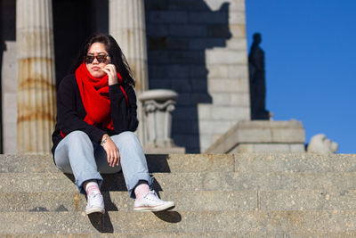 Full length of woman sitting on staircase