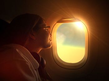 Smiling girl looking through airplane window
