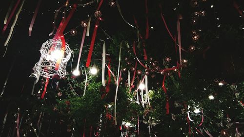Low angle view of illuminated lanterns hanging against sky