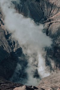 High angle view of smoke emitting from volcanic mountain