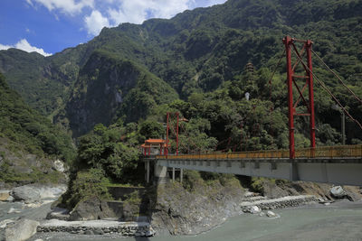 Bridge over mountain against sky