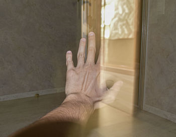 Midsection of person touching wall at home