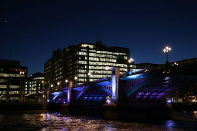 Bridge over river in city at night