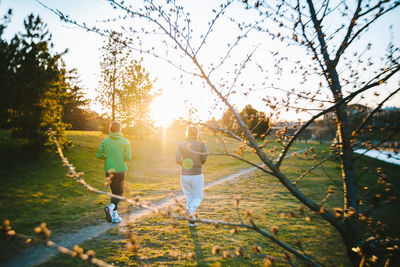 Rear view of people walking on plants