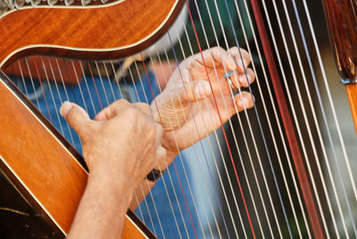Close-up shot of man hands playing harp outdoors in santiago, chile. concept of music, and  leisure