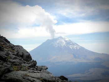 Scenic view of mountain range against cloudy sky