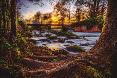 Scenic view of river against sky at sunset