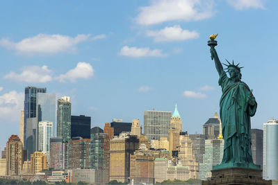 Statue of city buildings against cloudy sky