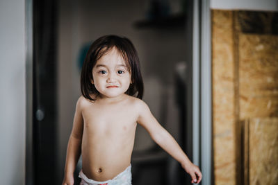 Portrait of cute girl standing at home